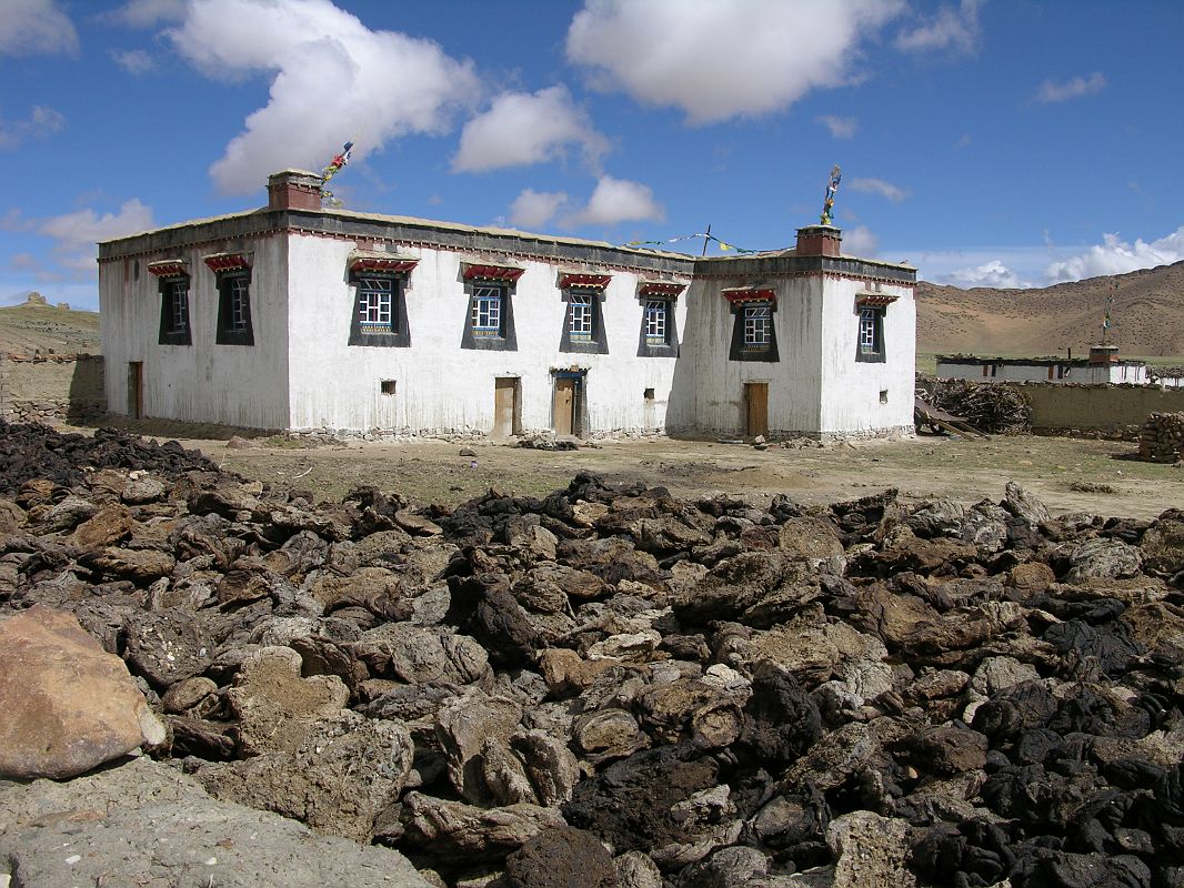 Shishapangma North 01 04 Siling Village House We walked to Siling village and enjoyed strolling around the houses. This is a fairly typical house, with yak dung drying in the foreground to later become fuel. The lower floor is for the animals, the upper floor for the people, and the roof for drying vegetables and spices.